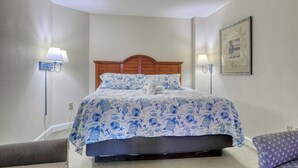 A hotel room with a bed, bedside lamps, a framed picture on the wall, and a ceiling fan. - HS-1109 Oceanfront 1-Bedroom Condo in Myrtle Beach - Sleeps 6 (Myrtle Beach)