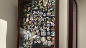 Dos conjuntos enmarcados de diversas insignias y pins exhibidos.