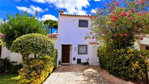 A two-story house with a tiled entrance, a small window with bars, and a door. - Villa Bella 200 meters from Falésia Beach by Urban Hypotenuse (Albufeira)
