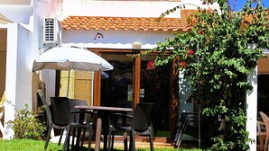 A house with a tiled roof, satellite dishes, and a patio with outdoor furniture. - Villa Bella 200 meters from Falésia Beach by Urban Hypotenuse (Albufeira)