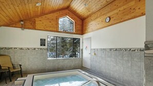 A wooden ceiling, a large window, a tiled wall, and a hot tub. - North Keystone 1 Bedroom Near Conference Center (Keystone)