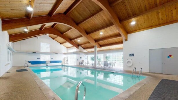 An indoor swimming pool with wooden beams, clear water, and a lifeguard chair. - North Keystone 1 Bedroom Near Conference Center (Keystone)