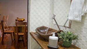 A wooden countertop with a soap dispenser, a wooden bowl, and a potted plant. - APTO VISTA MAR MELHOR LOCALIZAÇÃO (Fortaleza)
