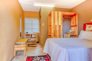 Cozy retreat with a single bed, wooden bench, and wardrobe, plus a mirror and small table.