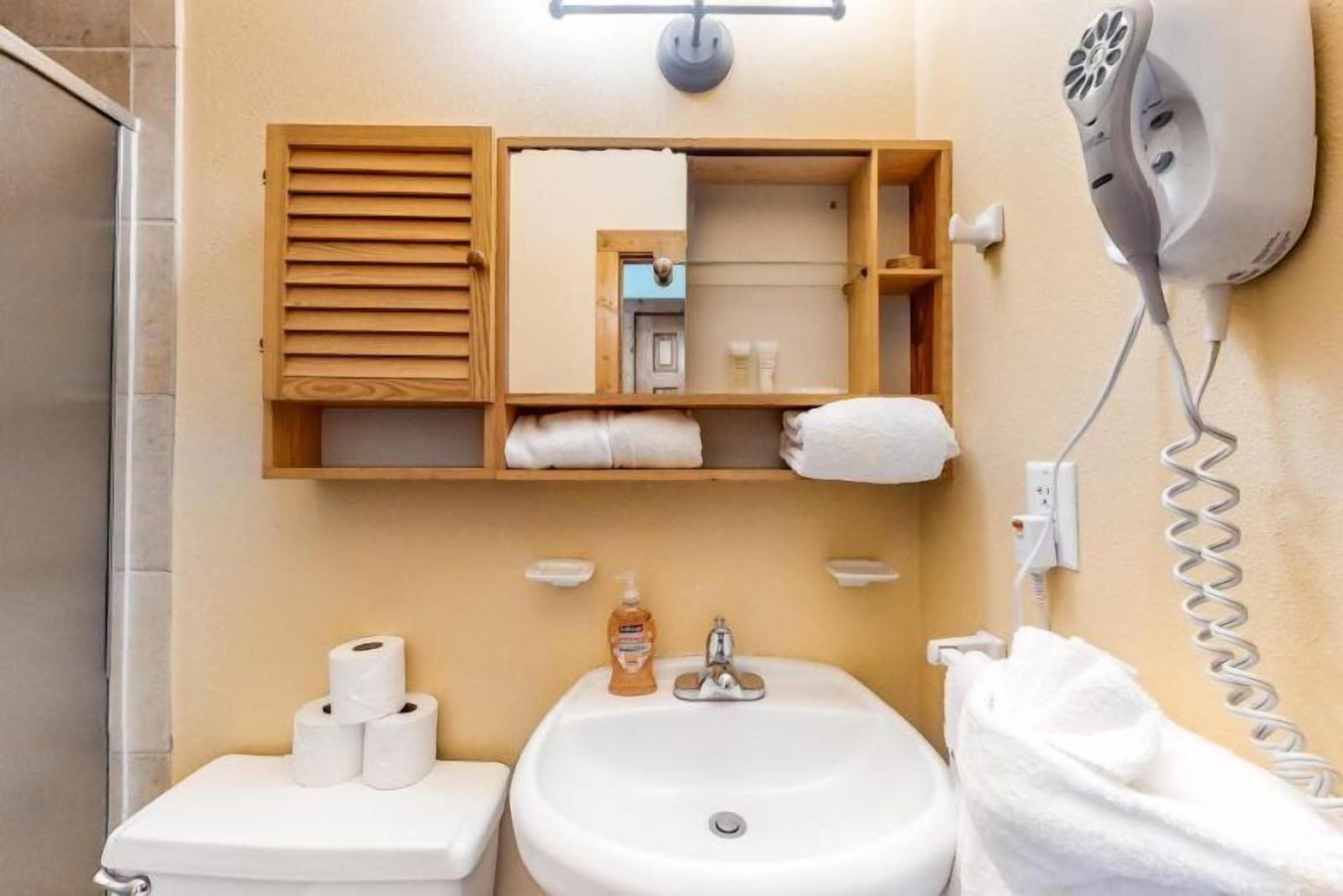 Une salle de bain équipée d’un lavabo, de toilettes et d’un porte-serviettes.