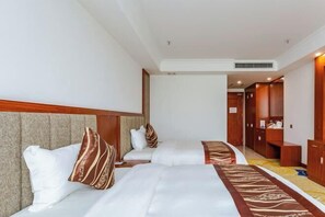 A hotel room with two beds, a wooden headboard, a carpeted floor, and a wardrobe. - Yaopeng Hotel (Qiannan)