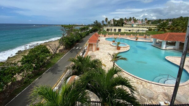 A resort with a swimming pool, a beach view, and a road leading to the property. - Spacious apartment with sea views, everything you need to spend your vacations. (Isabela)