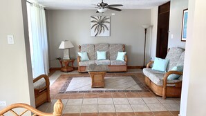 A living room with a ceiling fan, patterned sofas, a coffee table, and a decorative rug. - Spacious apartment with sea views, everything you need to spend your vacations. (Isabela)