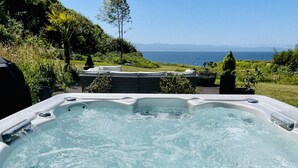 Uma banheira de hidromassagem com vista para o mar e as montanhas.