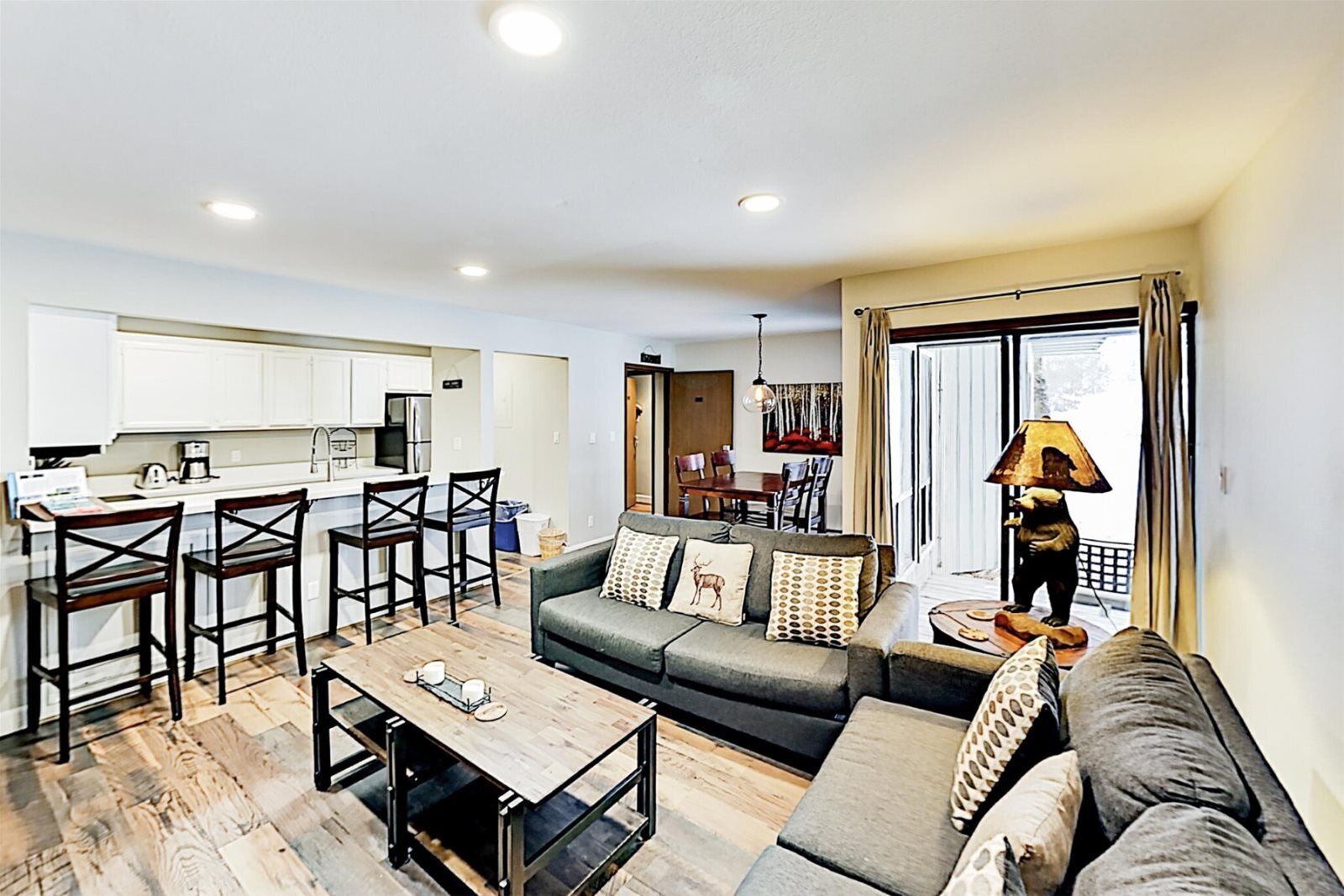 A modern apartment with a kitchen, dining area, and living room.