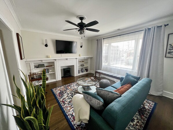 A living room with a sofa, a coffee table, a fireplace, and a television.