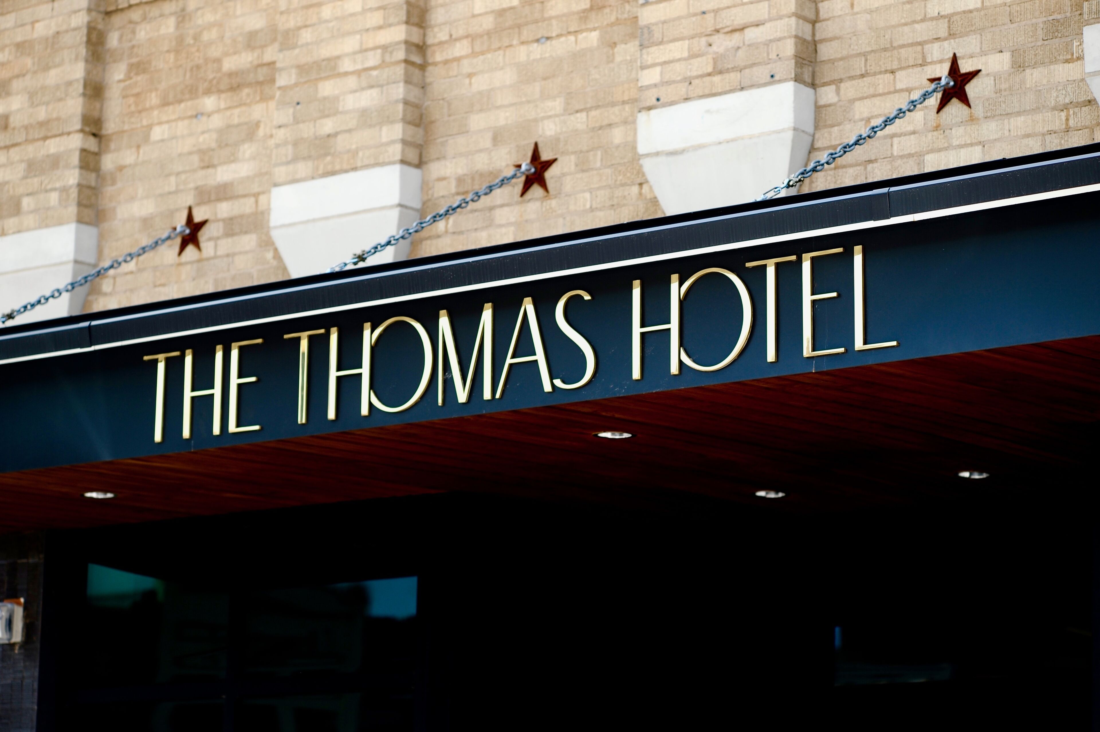 The exterior of The Thomas Hotel with a prominent sign and star decorations.