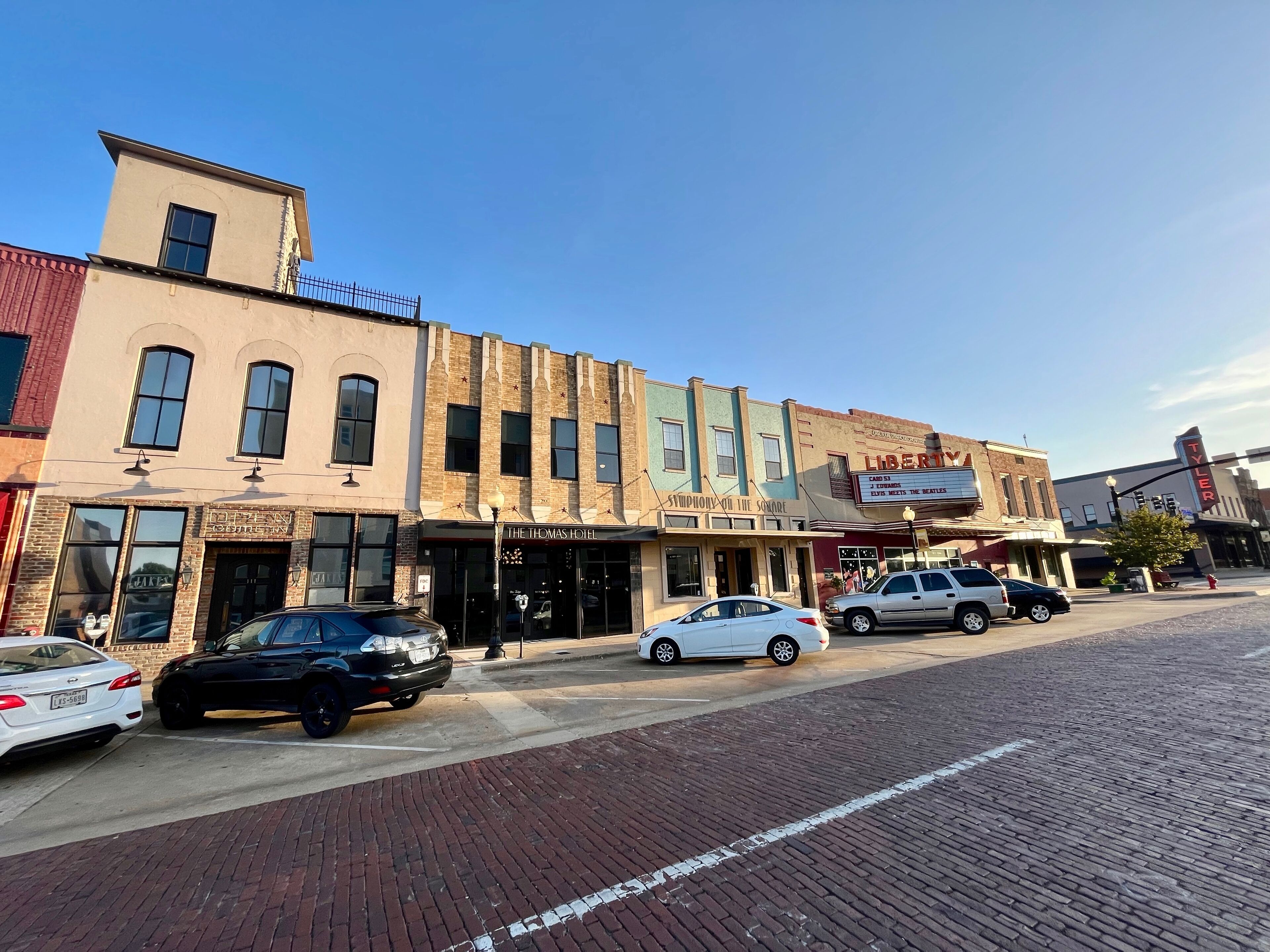 A street view with buildings including a hotel named 'The Thomas Hotel' and a theater named 'Liberty'.