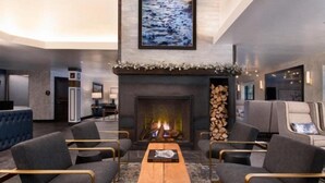 Un vestíbulo moderno con chimenea, zona de estar y un cuadro grande en la pared.