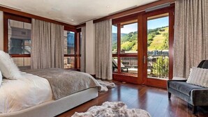 Une chambre spacieuse avec un grand lit, un canapé et un balcon offrant une vue panoramique.