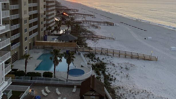 Un resort con piscina, acceso a la playa y vistas al atardecer.