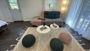 Un salon moderne avec un canapé, une table basse et un tapis.