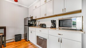 A modern kitchen with white cabinets, a stainless steel refrigerator, a built-in oven, and a coffee maker. - Gorgeous condo with hot tub, heated indoor pool, fireplace, balcony, & fast WiFi (Beech Mountain)