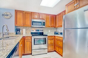 Enjoy cooking in this well-equipped kitchen with a refrigerator, microwave, oven, and coffee maker.