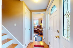 Staircase leads to a cozy living area with a comfortable chair, small table, and lamp.