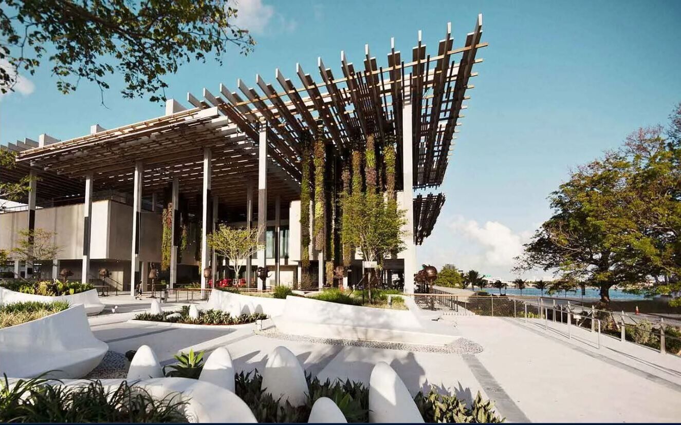 Een modern gebouw met een overdekt buitengebied, met een pergola, zitplekken en uitzicht op het water.