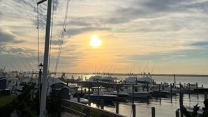 A flagpole with an American flag, a marina with boats, and a sunset in the background. - Cozy House less than two miles from Ocean Beaches (Hampton Bays)