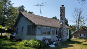 Una casa con un camino in pietra, un'antenna parabolica e un garage.