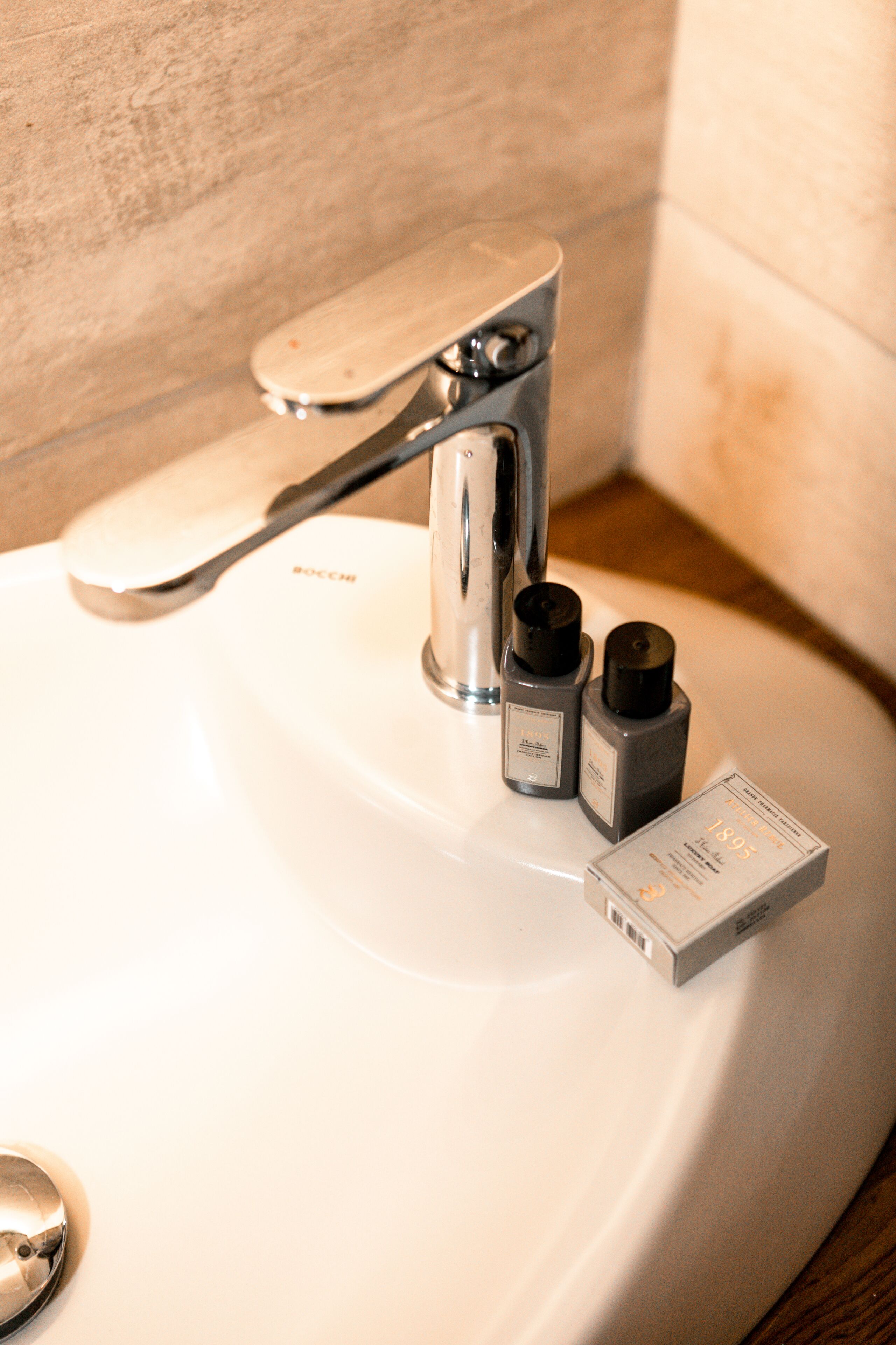 A bathroom sink with a modern faucet and two soap dispensers.