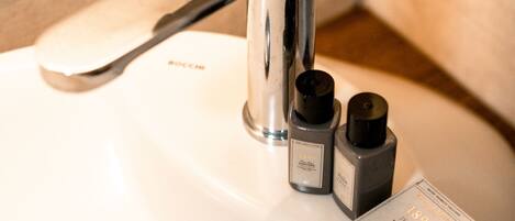A bathroom sink with a modern faucet and two soap dispensers.