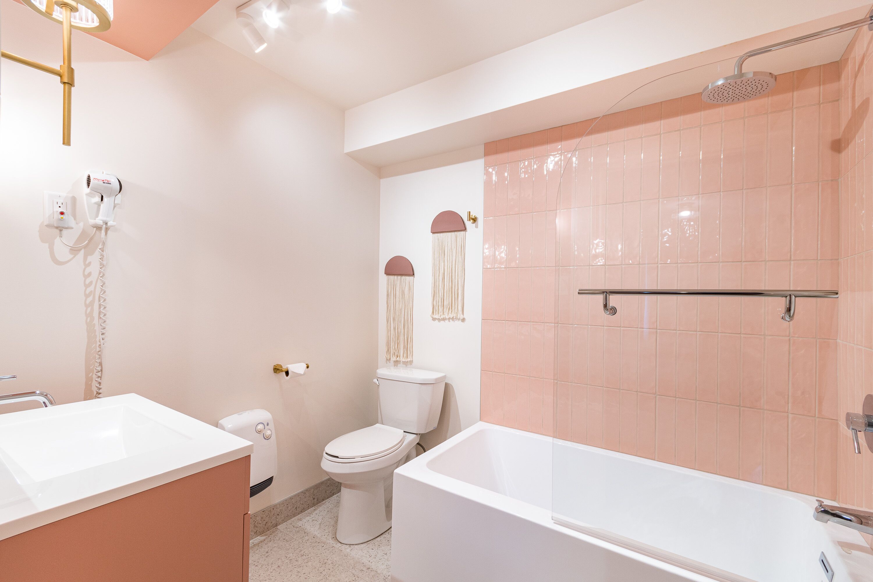 Un baño con lavamanos, inodoro y bañera blancos.