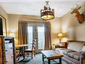 Traditional decor fills this inviting space with a dresser, table, sofa, and mounted deer head.