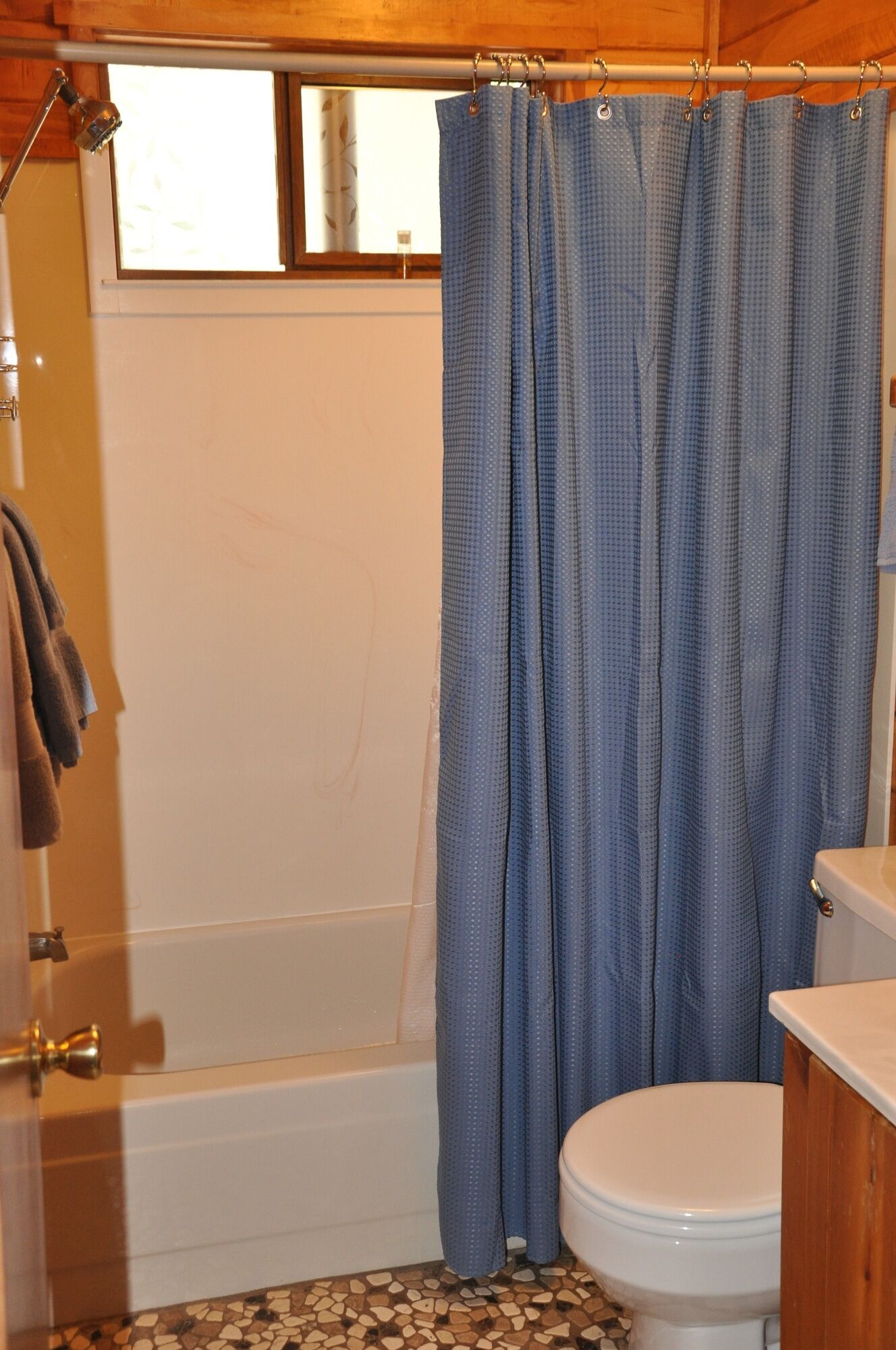 Een badkamer met een bad, toilet en douchegordijn.