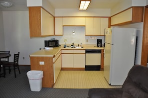 Compact kitchen area with a central island, microwave, sink, coffee maker, and refrigerator.
