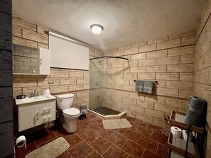 A bathroom with a toilet, sink, and shower.