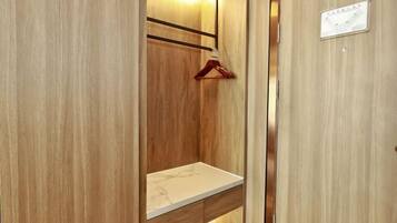 A wooden wardrobe with a hanging rack and a shelf.