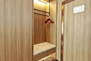 Un armario de madera con barra para colgar y un estante.