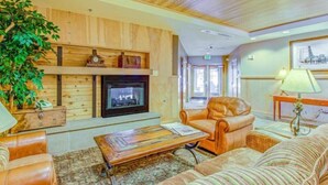 A cozy lobby with a fireplace, leather seating, and a large plant. - Silvermill Lodge 1 Bedroom in River Run Village (Keystone)