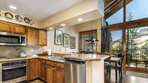 Een moderne keuken met houten kastjes, roestvrijstalen apparatuur en een groot eiland.