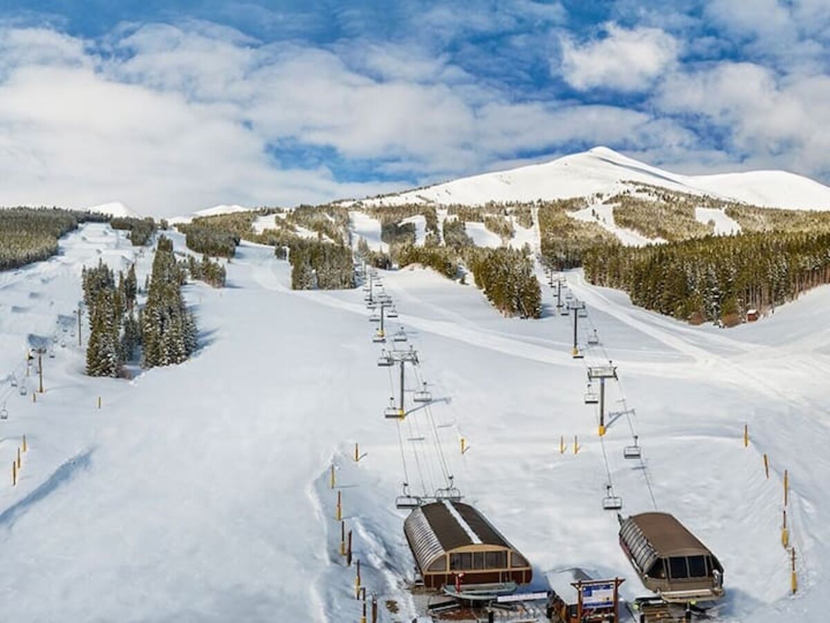 Une station de ski dotée d’un télésiège, de pistes enneigées et offrant une vue imprenable sur les montagnes.