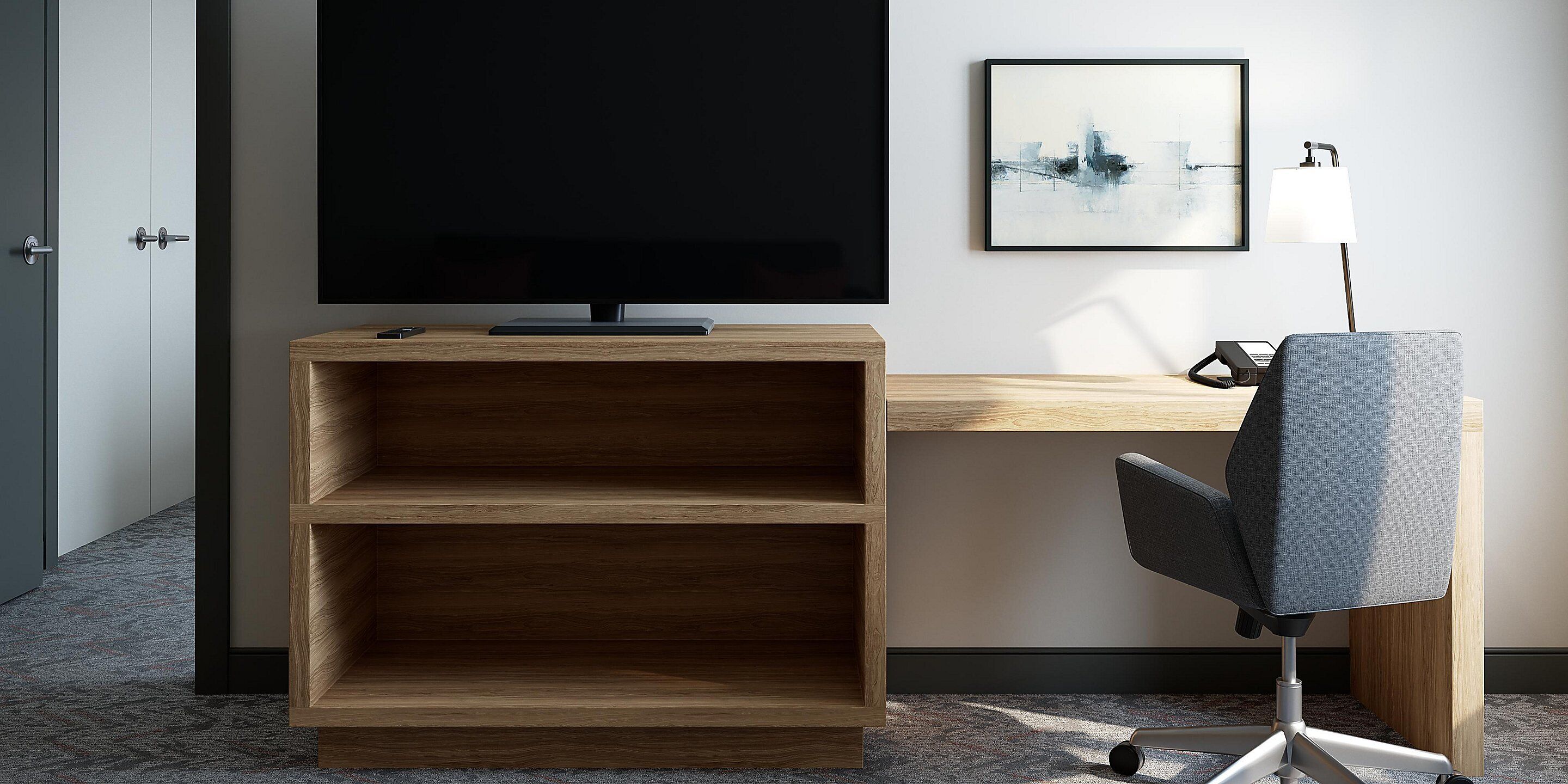 A modern office space with a large flat-screen TV, a desk, a chair, and a shelf unit.