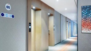 A modern hallway with a digital sign displaying room numbers and directions. - Holiday Inn Express Cangzhou High Tech Zone by IHG (Cangzhou)