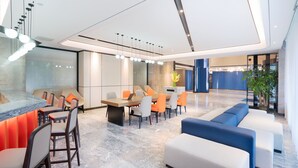 A modern lobby with a reception desk, seating area, and a large window. - Holiday Inn Express Cangzhou High Tech Zone by IHG (Cangzhou)