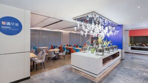 A modern breakfast area with a buffet setup, including a variety of food containers and a decorative centerpiece. - Holiday Inn Express Cangzhou High Tech Zone by IHG (Cangzhou)