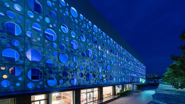 A modern building with a facade of circular windows. - Holiday Inn Express Cangzhou High Tech Zone by IHG (Cangzhou)