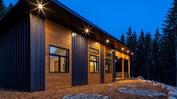 A modern building with a wooden exterior and large windows, surrounded by a forested area. - Red Fox Lodge, 2 bedroom, 2 bathroom with Hot Tub (Golden)