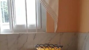 Kompakti keittiö, jossa on mikroaaltouuni ja pieni jääkaappi.