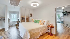 A bedroom with a large bed, a small table, a chair, a desk, and a window. - Epic Brunswick Apartment with Hot Tub! (Brunswick)