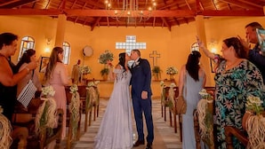 Una ceremonia de boda en un salón con vigas de madera y una araña.