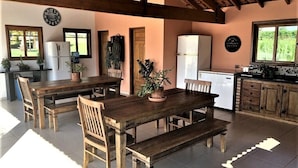 Una cocina rústica con muebles de madera, un refrigerador y un reloj en la pared.