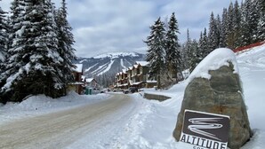 Een met sneeuw bedekte weg met een bord waarop staat: 'ALTITUDE 5050'.